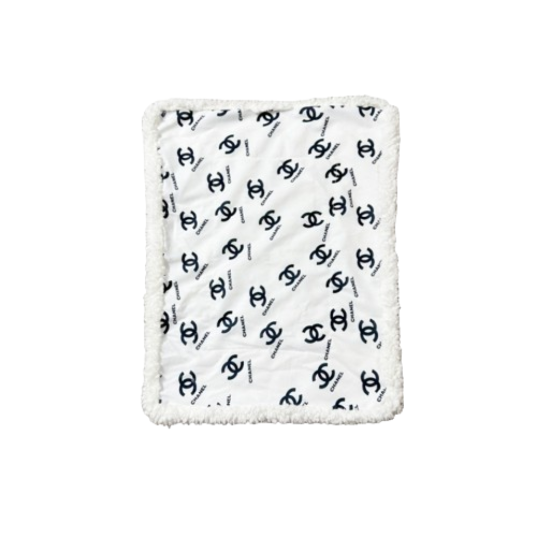 White and black Chanel inspired dog bed with interlocking logo pattern and plush sherpa border trim